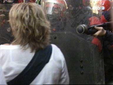 Policeman aiming at the torso of a demonstrator