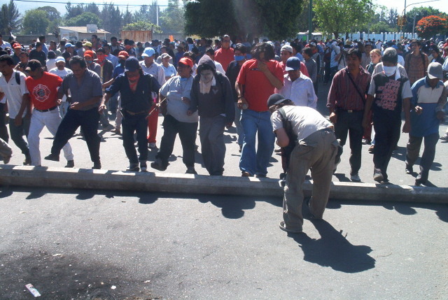 Grote betonnen paal wordt naar de barricades gerold 