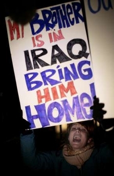 An anti-war protester shouts slogans as she holds a banner outside the W.H.