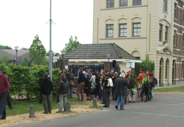 ongeveer 50 mensen maken een helse kabaal voor de poort.