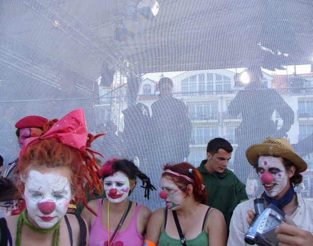 Linie politie op het podium, linie ervoor en daarvoor een linie clowns