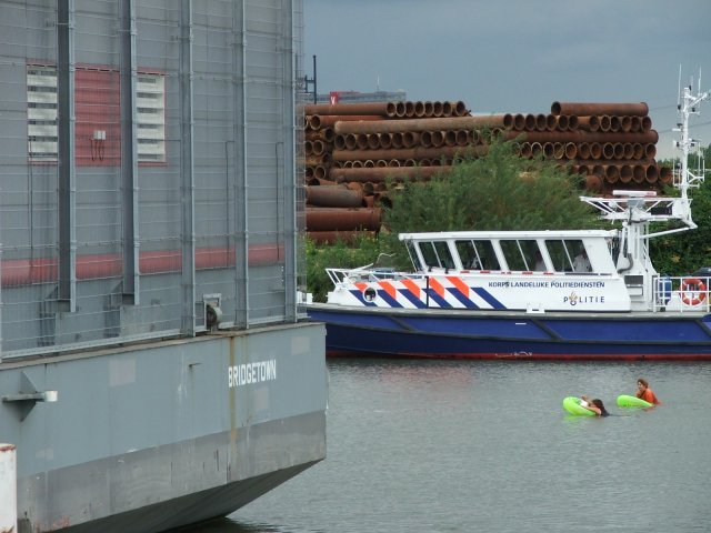 De zwemsters op weg, begeleid door politieboot