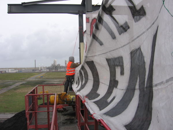 Het ophangen van de spandoek bij windkracht 4 a 5