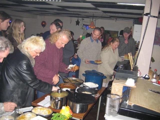 Mensen scheppen hun bord vol aan het lopend buffet