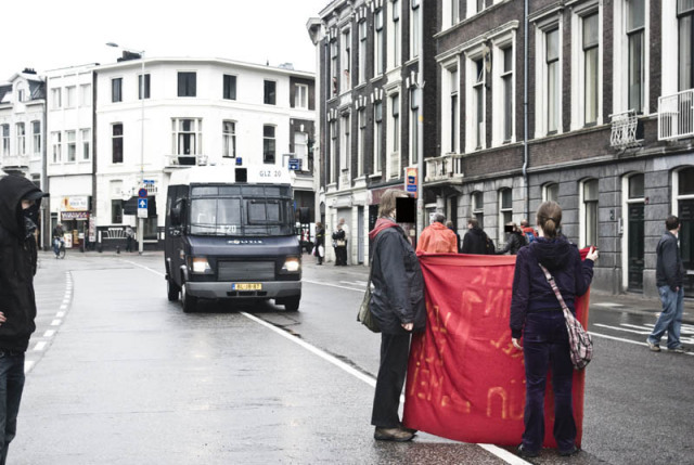 Two people block a police van