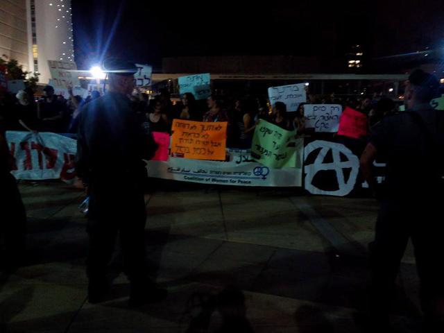 Israeli anti-war protesters stand together.