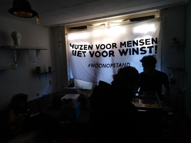 In het huis hangt een spandoek met ‘Huizen voor mensen, niet voor winst'