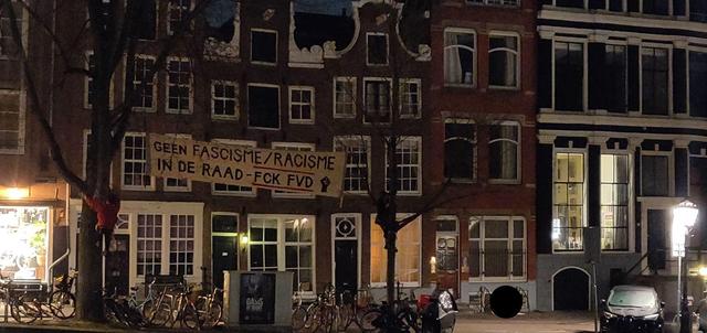 Het spandoek en lkimmers in de boom voor het FVD kantoor